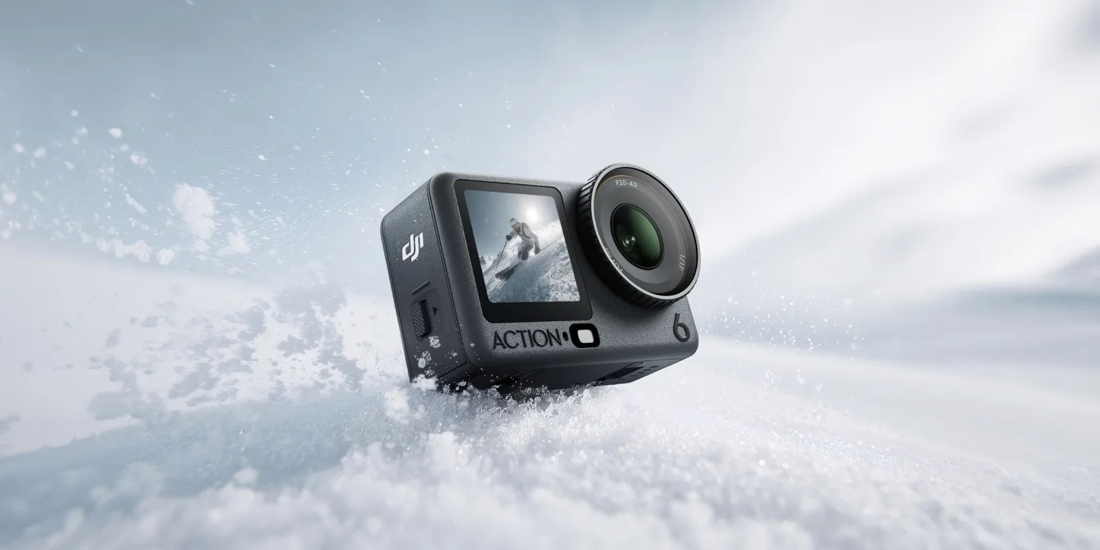 The DJI Osmo Action 6 half buried in snow, with its front screen showing a skier and the f/2.0 to f/4.0 lens ring
