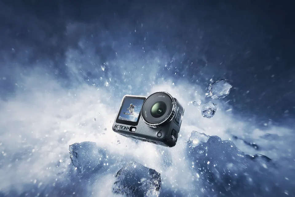 The DJI Osmo Action 6 flying through a burst of snow and ice against a dark blue sky